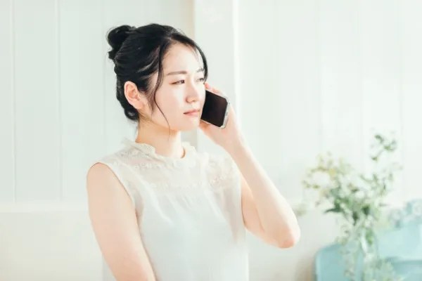 電話で鍵屋に相談する女性