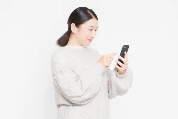 スマートフォンで鍵屋を調べる女性